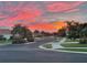Beautiful street view with landscaped homes and lush trees underneath a gorgeous pink and orange sunset at 6240 Falcon Lair Dr, North Port, FL 34287