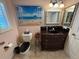 Bathroom featuring a seascape mural, window with shutters, and dark wood vanity at 652 N Elm St, Englewood, FL 34223