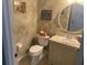 Functional powder room featuring textured walls, artwork, toilet, vanity, sink, and large mirror at 652 N Elm St, Englewood, FL 34223