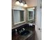 Bathroom with a vanity, framed mirror, black countertops and neutral wall color at 652 N Elm St, Englewood, FL 34223