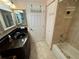 Bathroom featuring vanity with black countertop, tiled floors, and shower-tub combo at 652 N Elm St, Englewood, FL 34223