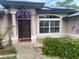 Charming home featuring a welcoming front entrance with decorative floral accents, solar panels, and a cozy butterfly bench at 652 N Elm St, Englewood, FL 34223