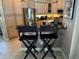 A beautifully appointed kitchen with stainless steel appliances and black bar chairs at 652 N Elm St, Englewood, FL 34223