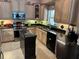 Shows the kitchen with stainless appliances and black granite countertops at 652 N Elm St, Englewood, FL 34223