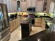 Open kitchen with granite countertops, stainless steel appliances, and central island at 652 N Elm St, Englewood, FL 34223