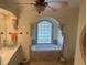 Elegant bathroom with garden tub beneath arch window and dual sinks at 652 N Elm St, Englewood, FL 34223