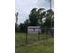 Backyard view of storage shed behind a chainlink fence surrounded by greenery at 652 N Elm St, Englewood, FL 34223