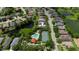 A stunning aerial view of a home with a pool, tennis court, and gazebo near a serene pond at 6617 Cheswick St, Sarasota, FL 34243