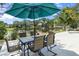 Outdoor dining area under an umbrella features a lovely pond view at 6617 Cheswick St, Sarasota, FL 34243