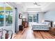 Bright bedroom with wood floors, tray ceilings, and sliding door access to the patio at 6617 Cheswick St, Sarasota, FL 34243