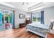 Bedroom features wood floors, tray ceilings, and sliding door access to the patio at 6617 Cheswick St, Sarasota, FL 34243