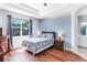 Relaxing bedroom features wood flooring, a large window, and soft blue accents at 6617 Cheswick St, Sarasota, FL 34243
