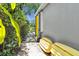 Property exterior featuring a secluded walkway, vibrant yellow trim, and a partial view of a serene lake at 6617 Cheswick St, Sarasota, FL 34243