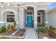 Inviting front entrance with blue door and decorative plants at 6617 Cheswick St, Sarasota, FL 34243