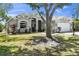 Beautifully landscaped single-story home with lush lawn, mature trees, and a spacious two-car garage at 6617 Cheswick St, Sarasota, FL 34243