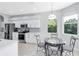 Bright kitchen features stainless steel appliances, white cabinets, and a breakfast nook near the window at 6617 Cheswick St, Sarasota, FL 34243