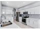 Clean kitchen featuring stainless steel appliances, and white cabinetry offering ample storage, and tiled backsplash at 6617 Cheswick St, Sarasota, FL 34243