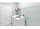 Modern laundry room with a washing machine, a dryer, and shelving at 6617 Cheswick St, Sarasota, FL 34243