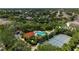 Aerial view of the community pool and tennis courts surrounded by lush greenery in a serene neighborhood setting at 6617 Cheswick St, Sarasota, FL 34243