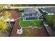 A beautiful aerial view of a home with an artificial turf lawn, and a screened in lanai with a pool at 6875 Beckwith Ave, North Port, FL 34291
