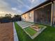 Backyard view of outdoor space with patio, artificial grass, and view into screened room of home at 6875 Beckwith Ave, North Port, FL 34291