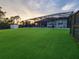 Spacious backyard featuring lush turf, a screened-in pool, and ample room for outdoor enjoyment at 6875 Beckwith Ave, North Port, FL 34291