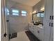 Bathroom features a double vanity, large mirror, and tiled walk-in shower at 6875 Beckwith Ave, North Port, FL 34291