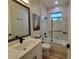 Bright bathroom featuring a shower over the bathtub, black fixtures and modern accents at 6875 Beckwith Ave, North Port, FL 34291
