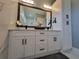 Bathroom showcasing a vanity with white cabinets, quartz countertop, dual mirrors, and decorative light fixtures at 6875 Beckwith Ave, North Port, FL 34291