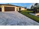 Home exterior with paver driveway, manicured lawn, and modern privacy fence at 6875 Beckwith Ave, North Port, FL 34291