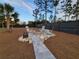 Paver walkway leads to backyard fire pit with Adirondack chairs, surrounded by landscaping at 6875 Beckwith Ave, North Port, FL 34291