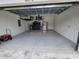 Spacious garage with epoxy flooring, overhead storage, and stainless steel refrigerator at 6875 Beckwith Ave, North Port, FL 34291
