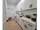 Laundry room featuring modern appliances, sink, and ample cabinet space at 6875 Beckwith Ave, North Port, FL 34291