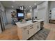 Modern open-concept with a kitchen island overlooking the living room with a fireplace, perfect for entertaining guests at 6875 Beckwith Ave, North Port, FL 34291