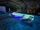 Screened pool with in-pool chaise lounges and colorful accent lighting for evening ambiance at 6875 Beckwith Ave, North Port, FL 34291