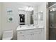 Bright bathroom featuring double vanity, well-lit mirror, and tiled shower at 7019 River Hammock Dr # 306, Bradenton, FL 34212