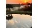 Scenic golf course view featuring an expansive green and water feature at sunset at 7019 River Hammock Dr # 306, Bradenton, FL 34212