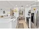 Open kitchen with stainless steel appliances, white cabinets, and adjacent dining area at 7019 River Hammock Dr # 306, Bradenton, FL 34212