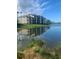 Reflective lake view featuring modern condo buildings and verdant landscapes, reflecting the community's peaceful appeal at 7019 River Hammock Dr # 306, Bradenton, FL 34212