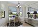 Bright home office with custom desk, lush outdoor views, and a decorative chandelier at 7019 River Hammock Dr # 306, Bradenton, FL 34212