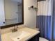 Bathroom with stone countertop, decorative mirror, and tiled shower at 725 Capri Isles Blvd # 217, Venice, FL 34292