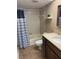 Bathroom featuring a shower-tub combo with a decorative curtain and a stone countertop at 725 Capri Isles Blvd # 217, Venice, FL 34292