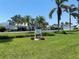 Entrance to the community with lush greenery and palm trees at 725 Capri Isles Blvd # 217, Venice, FL 34292