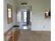A spacious hallway with a view of the front door and a glass topped console table at 725 Capri Isles Blvd # 217, Venice, FL 34292
