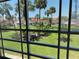 View from the screened lanai of a verdant, landscaped lawn with mature palm trees at 725 Capri Isles Blvd # 217, Venice, FL 34292