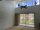 Bright living room with high ceilings, transom windows, a ceiling fan, and sliding glass doors to the lanai at 725 Capri Isles Blvd # 217, Venice, FL 34292