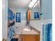 Cozy blue bathroom with tiled floors, framed mirror, and shower with blue curtain at 7508 9Th N Ave, St Petersburg, FL 33710