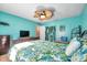 Bright bedroom featuring a leaf-themed bedspread, ceiling fan, and cheerful blue walls at 7508 9Th N Ave, St Petersburg, FL 33710