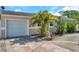 Beige single-story home with a well-maintained lawn, lovely flowers and a one car garage at 7508 9Th N Ave, St Petersburg, FL 33710