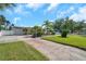 Charming single-story home with well-manicured lawn, palm trees, and brick driveway at 7508 9Th N Ave, St Petersburg, FL 33710